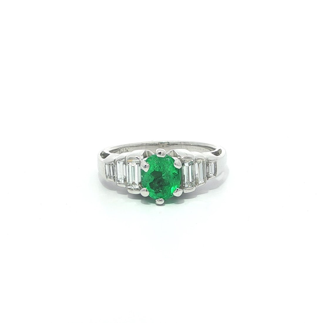 14k White Gold 1.33ct Oval Green Emerald and Diamond Ring: 14k White Gold 1.33ct Oval Green Emerald and Diamond Ring This exquisite ring showcases a stunning 1.33ct oval bright green emerald, elegantly prong set and complemented by six baguette diamonds, chan