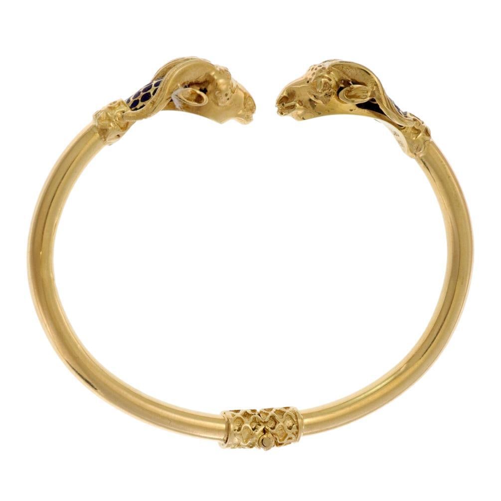 14k Yellow Gold Ram's Head Cuff Bracelet with Blue Enamel: 14k Yellow Gold Ram's Head Cuff Bracelet with Blue Enamel This exquisite Ram's Head Cuff Bracelet is meticulously crafted from 14k yellow gold, showcasing a classic flex cuff design. The bracelet feat