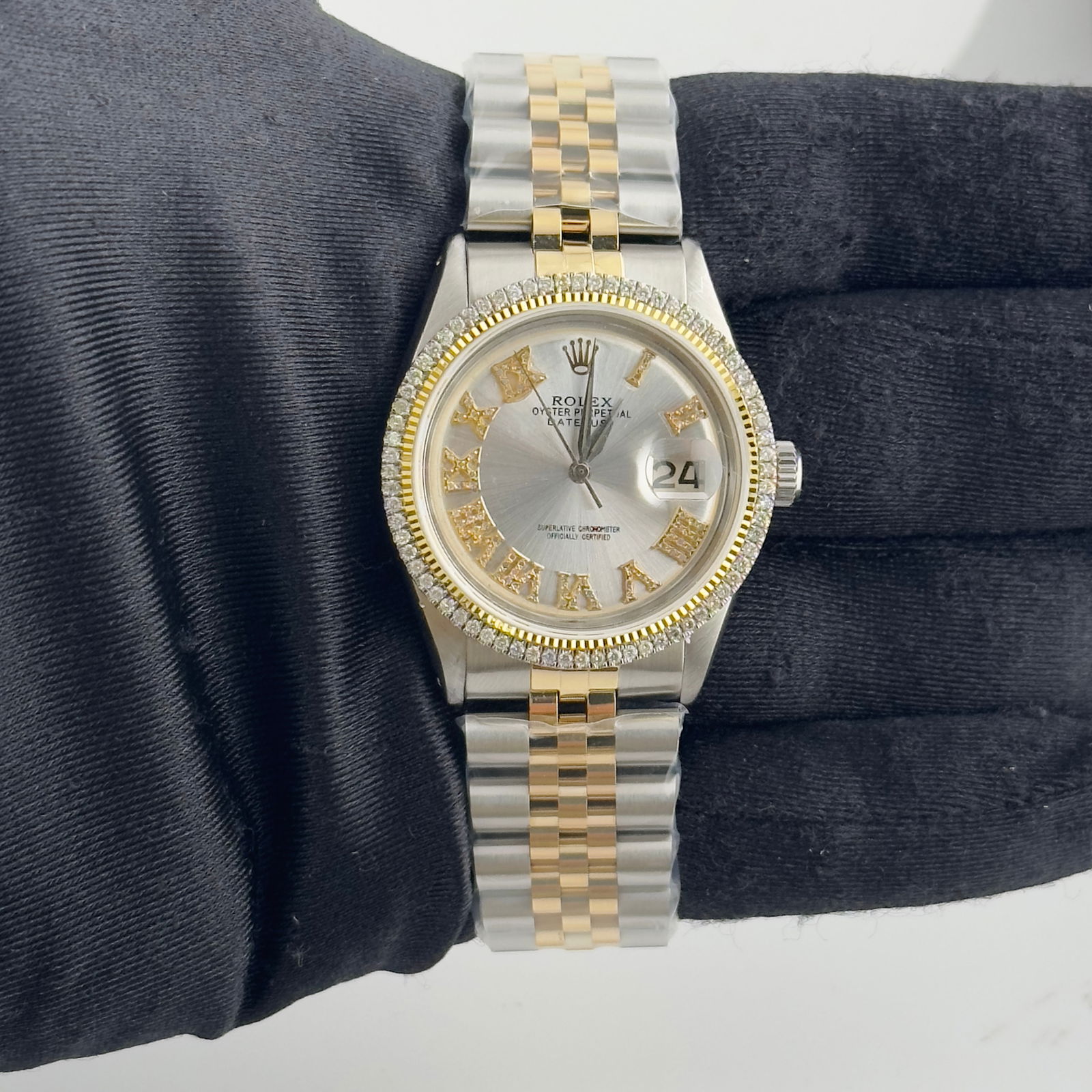 Aftermarket Silver Roman Diamond Dial Jubilee Rolex Datejust 1601: Aftermarket Silver Roman Diamond Dial Jubilee Rolex Datejust 1601 This Rolex Datejust watch features an aftermarket silver dial with Roman numerals and diamond accents. It is equipped with an aftermar