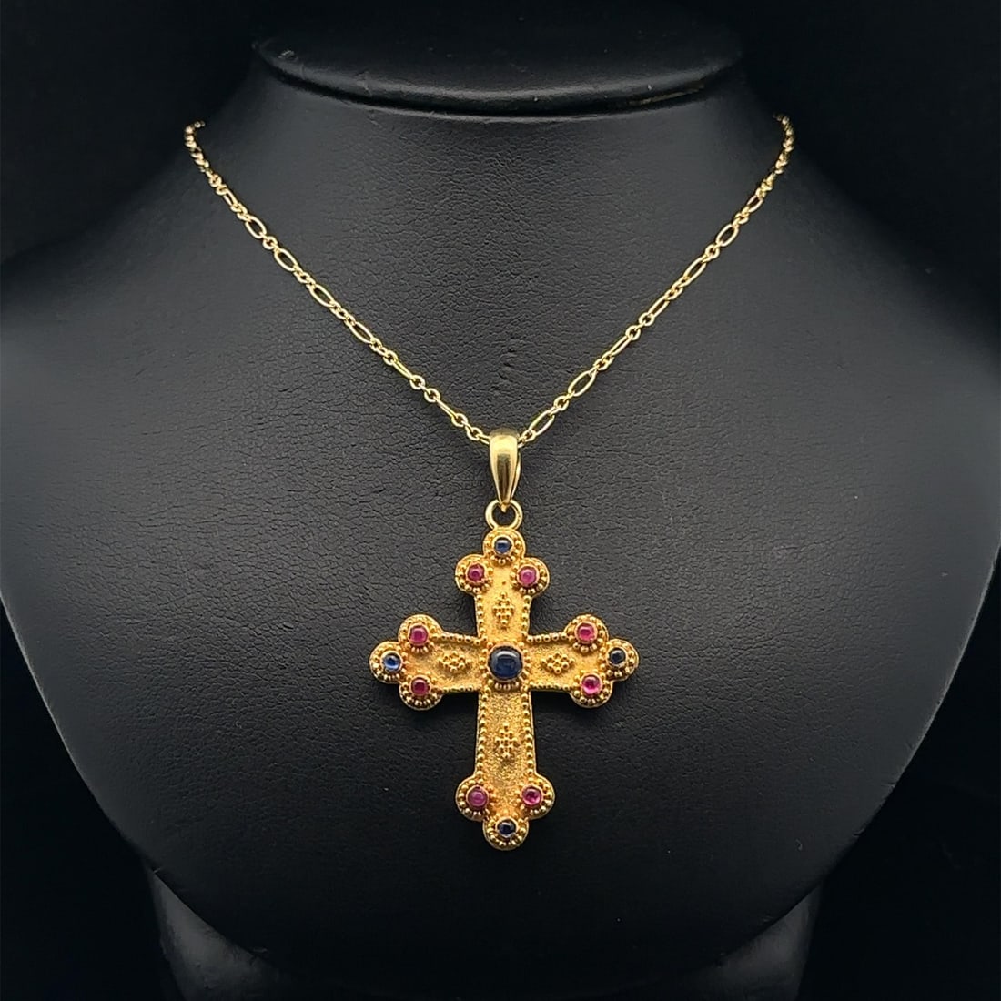 Orthodox Cross Pendant Necklace in 18k Gold with Ruby and Sapphire Accents: Orthodox Cross Pendant Necklace in 18k Gold with Ruby and Sapphire Accents This necklace features an Orthodox cross pendant crafted from solid 18k yellow gold, adorned with bead work using natural rub