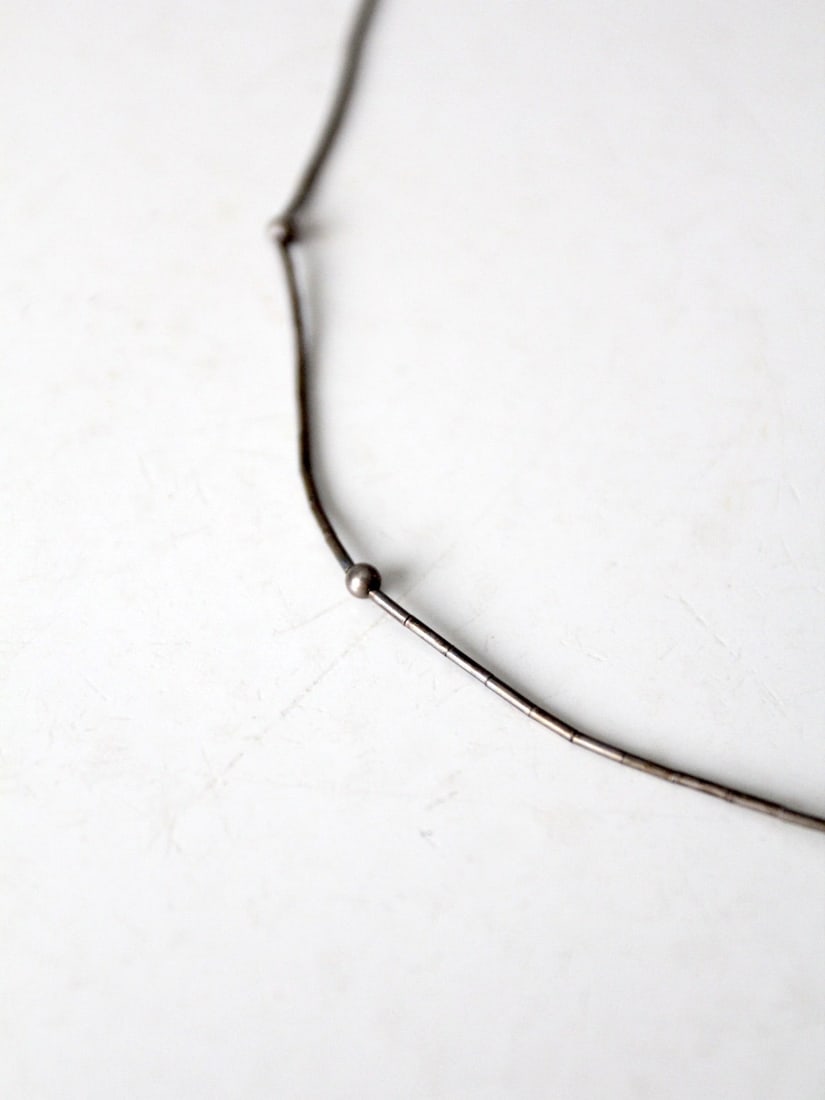 Vintage Silver Tone Heishi Bead Chain Necklace 15.75 in: Vintage Silver Tone Heishi Bead Chain Necklace 15.75 in This vintage silver tone chain necklace showcases a slender design adorned with heishi style beads and small silver tone ball accents. It featur
