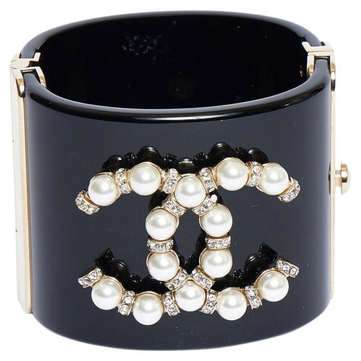 Chanel Vintage Black Lucite Cuff Bracelet with Pearl CC Logo: Chanel Vintage Black Lucite Cuff Bracelet with Pearl CC Logo This stunning Chanel vintage black lucite cuff bracelet showcases the iconic CC logo embellished with pearls and clear rhinestones. Crafted