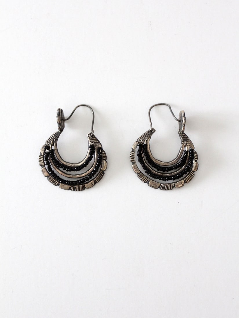 1970s Vintage Mexican Dangle Hoop Earrings with Black Beading: 1970s Vintage Mexican Dangle Hoop Earrings with Black Beading Explore a stunning pair of vintage Mexican dangle hoop earrings from the 1970s. These exquisite earrings are crafted from etched silver to
