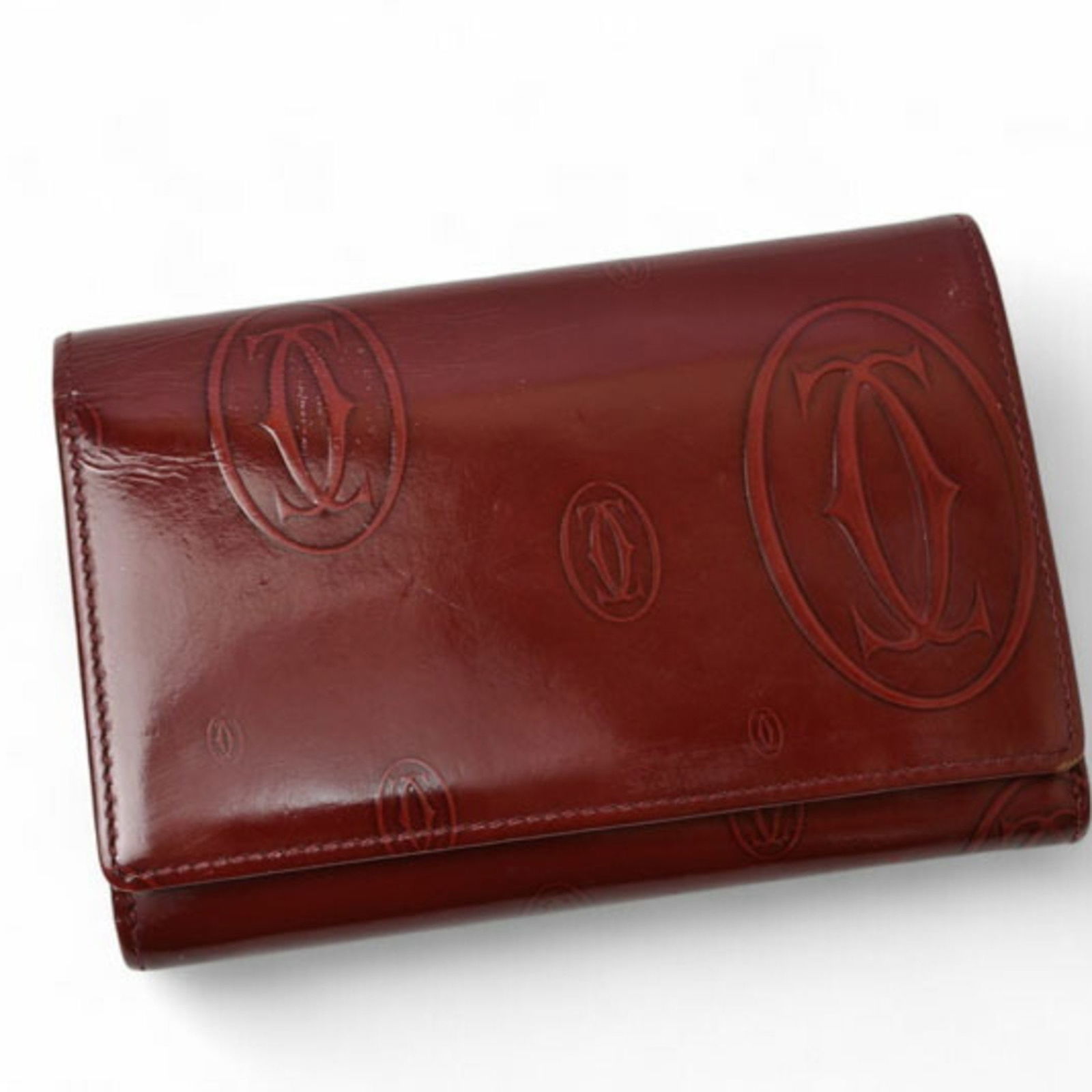 Burgundy Leather Cartier Happy Birthday Wallet with French Origin: Burgundy Leather Cartier Happy Birthday Wallet with French Origin This Cartier Happy Birthday wallet features a burgundy leather exterior with subtle traces of use and slightly rubbed corners. The int