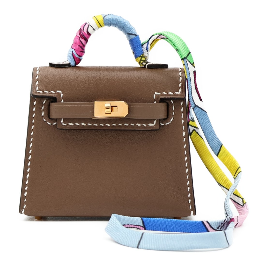 Kelly Twilly Bag Charm in Etoupe Tadelakt Leather with Gold Hardware: Kelly Twilly Bag Charm in Etoupe Tadelakt Leather with Gold Hardware This Hermes Kelly Twilly bag charm is crafted from Tadelakt calfskin leather in a gray shade. Designed as a stylish accessory, it f