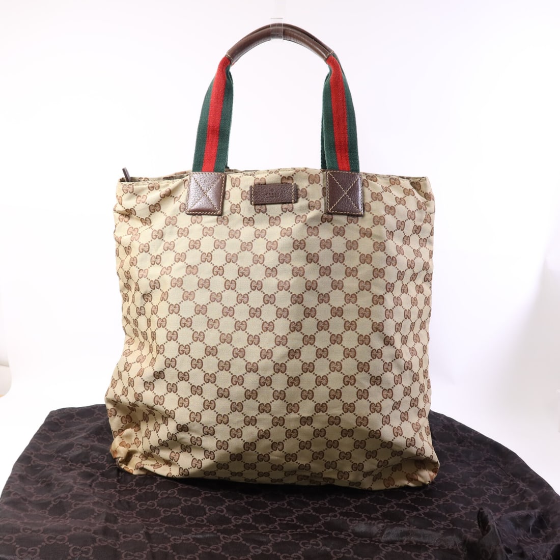 Beige GG Canvas Tote by Gucci Model 131233 with Silver Hardware: Beige GG Canvas Tote by Gucci Model 131233 with Silver Hardware This Gucci GG tote bag features a beige GG canvas exterior and offers a spacious design suitable for everyday use. Crafted in Italy, the