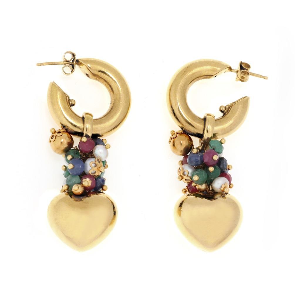 Elegant 18k Gold Heart Earrings with Ruby Emerald Sapphire Pearls: Elegant 18k Gold Heart Earrings with Ruby Emerald Sapphire Pearls These exquisite earrings are crafted from 18k yellow gold and feature a standard post hoop design. Dangling from the hoops is a vibran