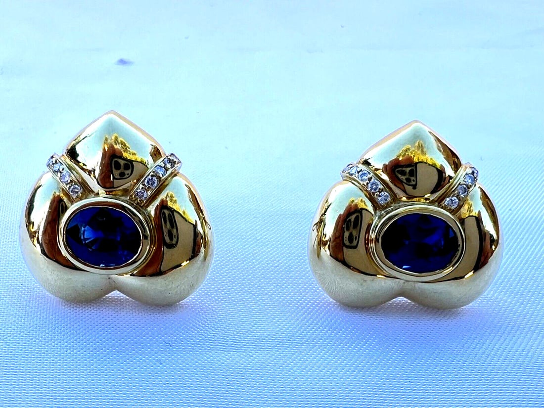 Neiman Marcus 18K Gold Heart Earrings with Sapphire and Diamonds: Neiman Marcus 18K Gold Heart Earrings with Sapphire and Diamonds Discover the elegance of this exquisite pair of earrings from Neiman Marcus, crafted in 18K yellow gold. These heart-shaped cuff earrin