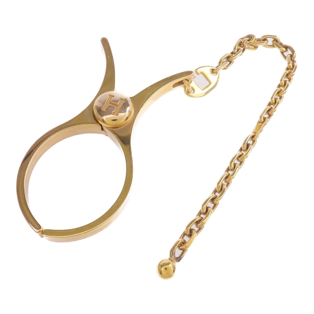 Gold Tone Metal Filou Glove Clip by Hermes France: Gold Tone Metal Filou Glove Clip by Hermes France Hermes Filou glove clip crafted from metal in a gold color. Made in France, this accessory is designed for securing gloves and features a sleek, styli