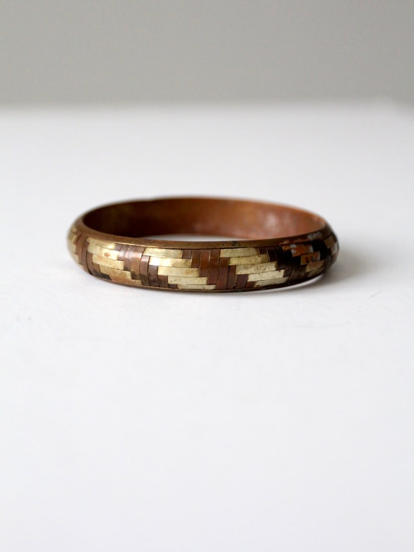 1970s Vintage Mixed Metal Basket Weave Cuff Bangle: 1970s Vintage Mixed Metal Basket Weave Cuff Bangle This vintage cuff bangle from the 1970s features a stunning mixed metal design incorporating copper, brass, and silver tones, beautifully crafted in