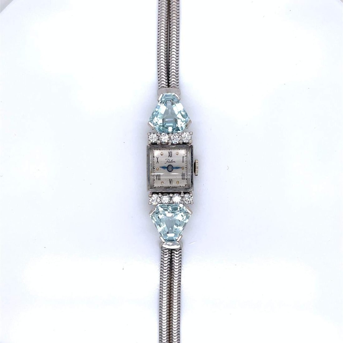1950s 14K White Gold Aquamarine Diamond Cocktail Watch Manual Wind: 1950s 14K White Gold Aquamarine Diamond Cocktail Watch Manual Wind This exquisite 1950's cocktail watch is crafted from 14K white gold and features a stunning combination of aquamarines and diamonds.