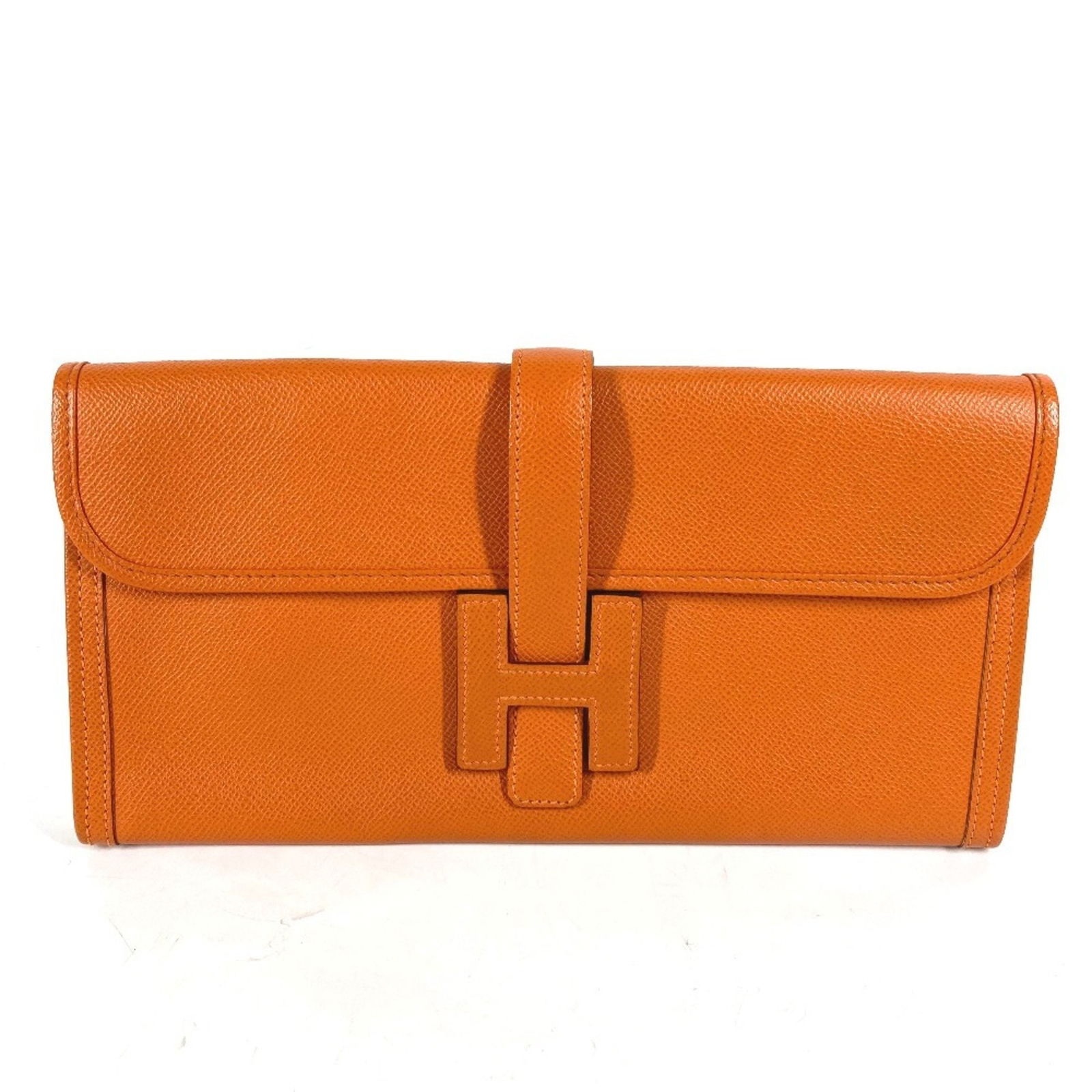 Orange Leather Jige Clutch by Hermes 14.5cm x 29cm: Orange Leather Jige Clutch by Hermes 14.5cm x 29cm This Hermes Jige clutch is crafted from orange leather and designed for women. The bag features a sleek silhouette with dimensions of 14.5cm x 29cm (