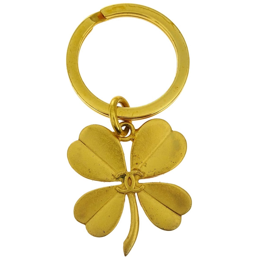Chanel Gold Plated Clover Key Holder Bag Charm 95A: Chanel Gold Plated Clover Key Holder Bag Charm 95A Enhance your accessories with this elegant Chanel Gold Key Holder Bag Charm in the shape of a clover. Crafted from gold-plated material, this keyring
