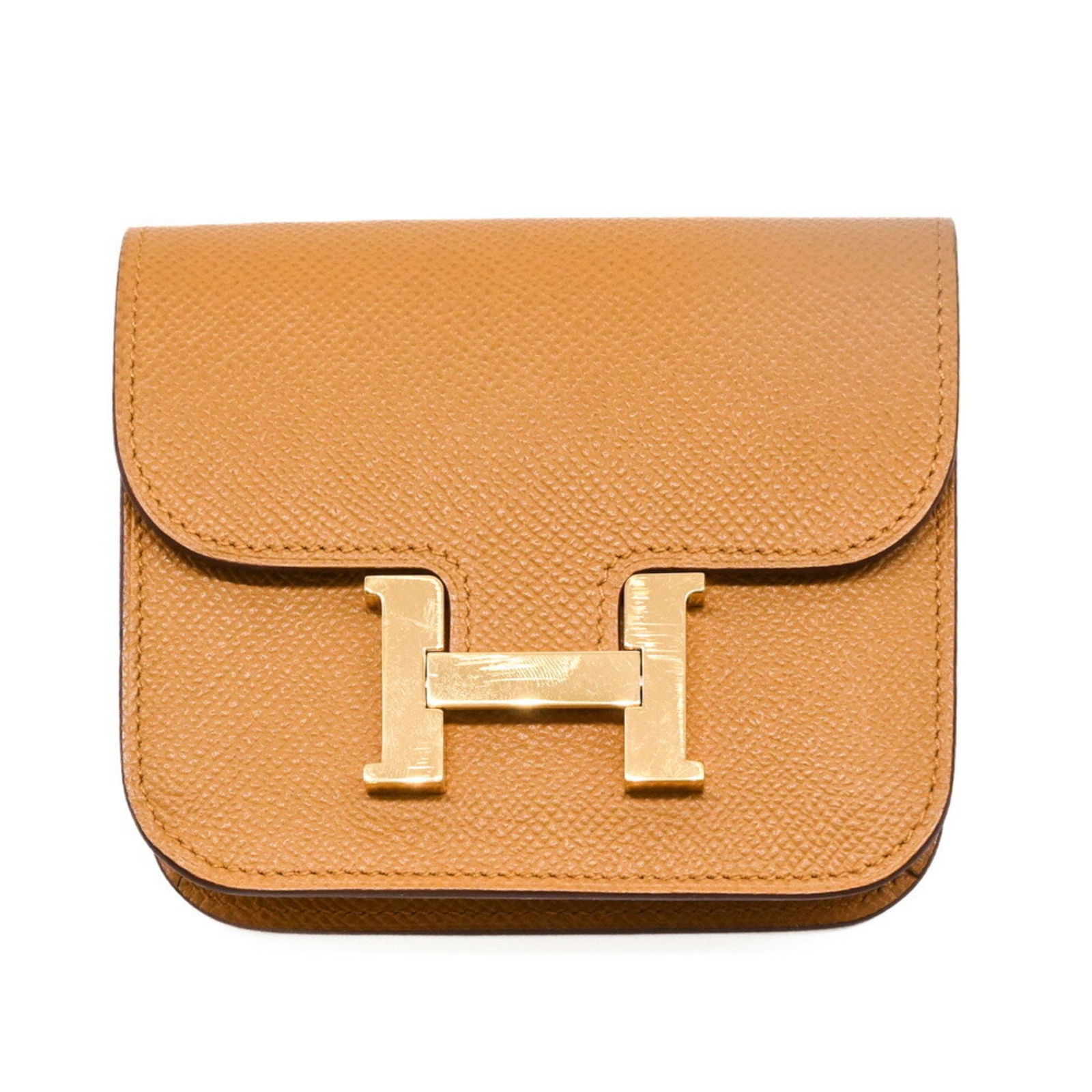 Brown Leather Constance Wallet by Hermes France: Brown Leather Constance Wallet by Hermes France The Hermes Constance is a unisex leather bag in brown, featuring a compact design. It is crafted in France and showcases subtle metal accents. The bag i