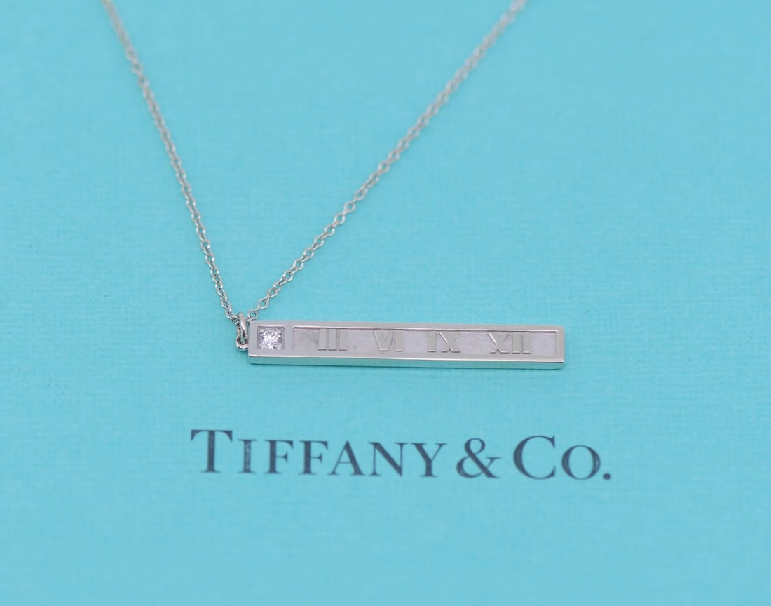 Tiffany & Co Atlas 18K White Gold Diamond Pendant Necklace: Tiffany & Co Atlas 18K White Gold Diamond Pendant Necklace This exquisite pendant necklace from Tiffany & Co. features a stunning design crafted in 18K white gold, showcasing a brilliant diamond at it