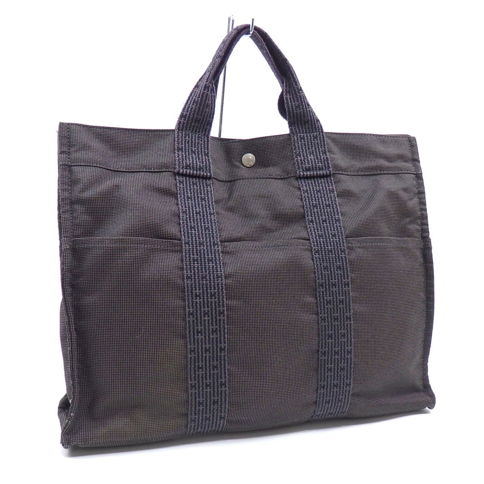 Grey Canvas Herline Tote Bag by Hermes France: Grey Canvas Herline Tote Bag by Hermes France This Hermes Herline tote is crafted from durable grey canvas, featuring a spacious interior and sturdy handles. It is designed for women and offers a prac