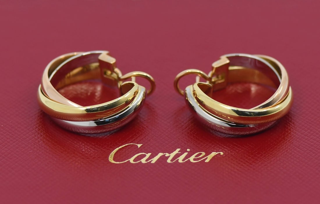 18k Multi-Tone Gold Trinity Hoop Earrings by Cartier with Pouch: 18k Multi-Tone Gold Trinity Hoop Earrings by Cartier with Pouch These Cartier Trinity earrings are crafted from 18K multi-tone gold in a classic hoop style. The earrings have a diameter of 25mm and a
