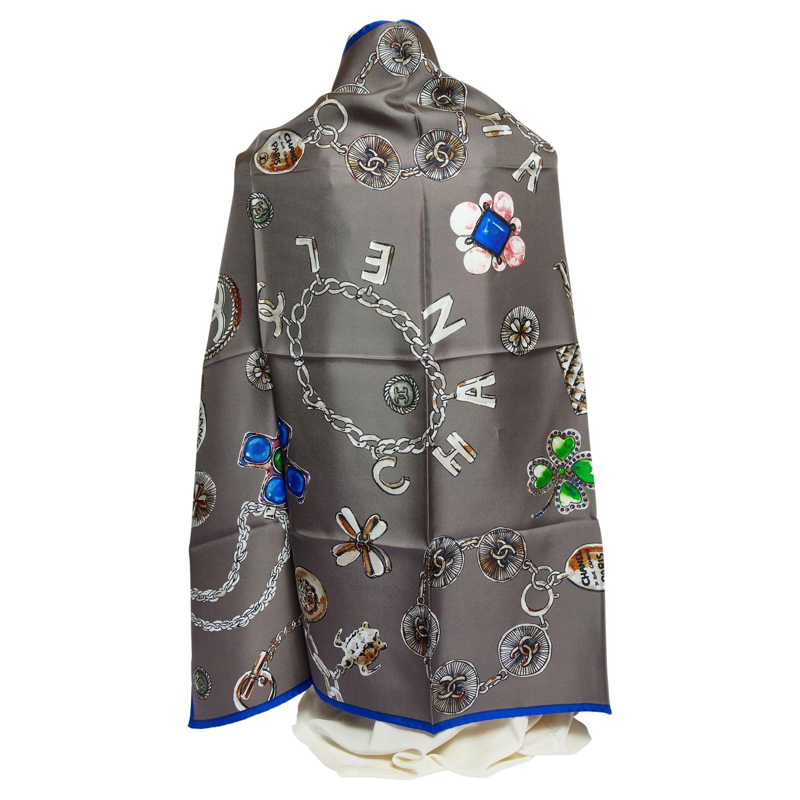 Chanel Grey Silk Shawl with Multicolor Jewelry Motifs: Chanel Grey Silk Shawl with Multicolor Jewelry Motifs Experience luxury with this exquisite Chanel silk shawl, showcasing a stunning multicolor pattern against a sophisticated grey background. The des