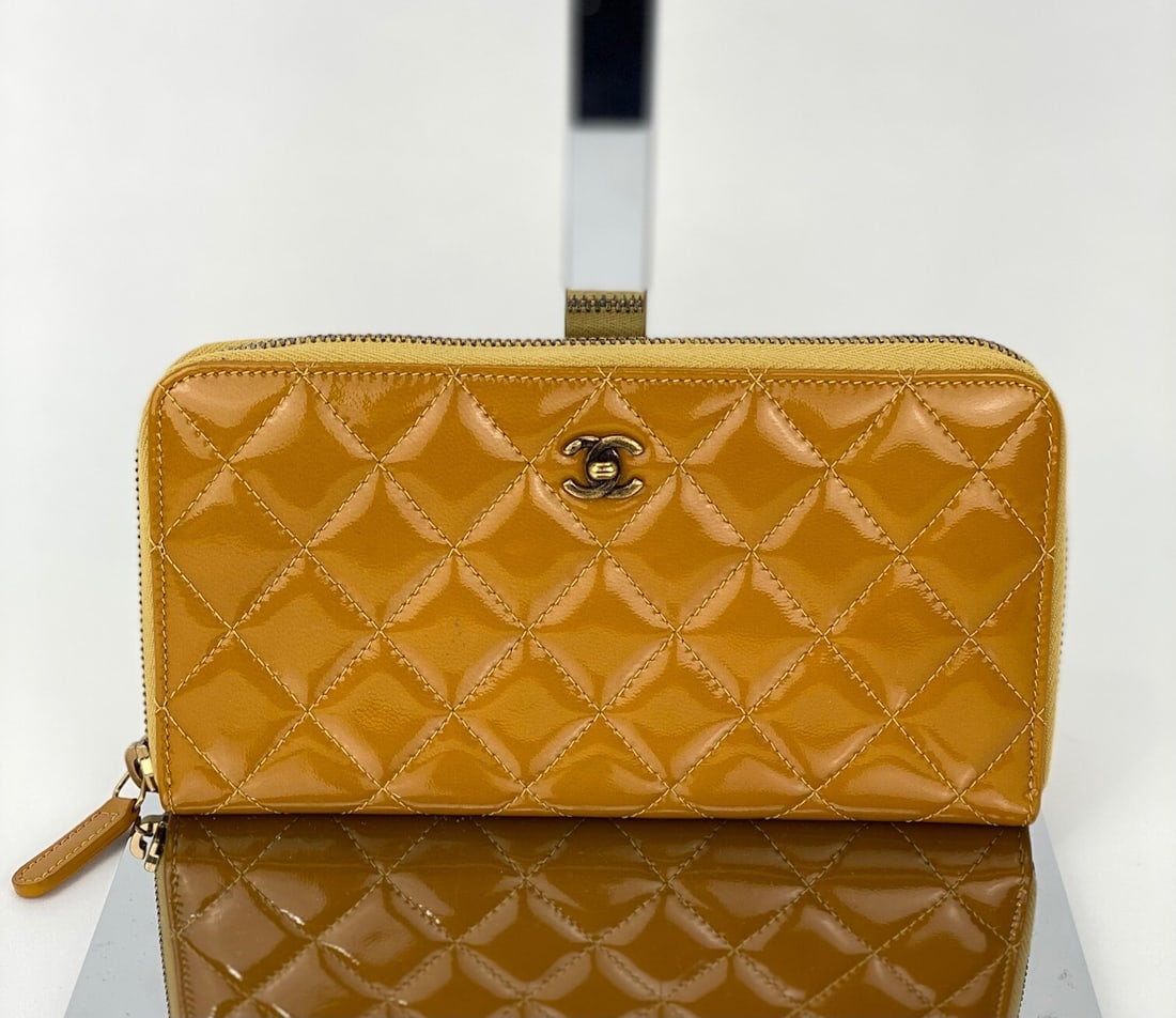 Chanel Yellow Patent Leather Quilted Zip Around Wallet: Chanel Yellow Patent Leather Quilted Zip Around Wallet Elevate your accessory collection with this Chanel Quilted Yellow Patent Leather Zip Around Wallet. Featuring a stylish quilted pattern, this wal