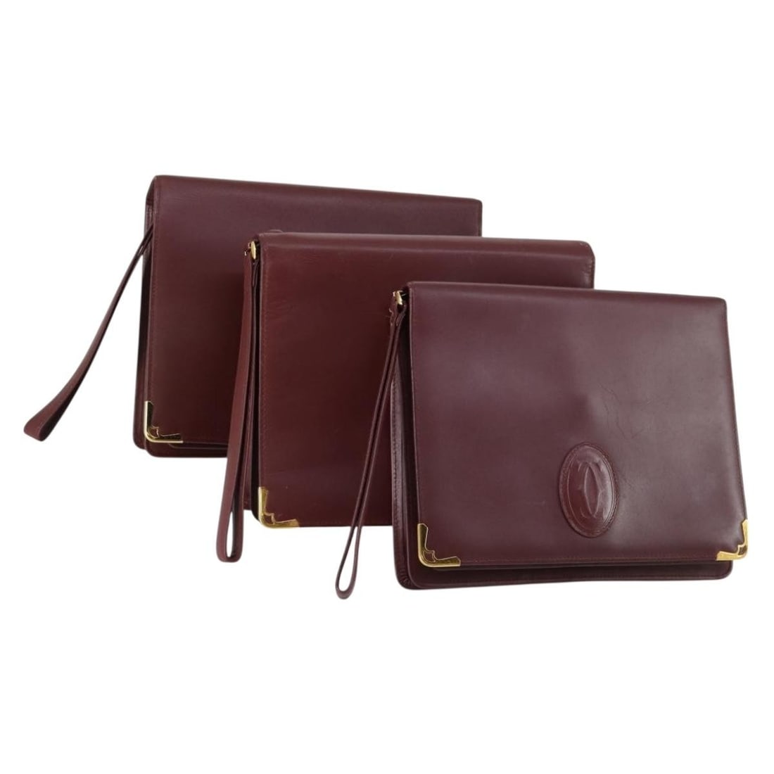 CARTIER Bordeaux Leather Clutch Bag Set of 3 with Auth Card: CARTIER Bordeaux Leather Clutch Bag Set of 3 with Auth Card Introducing the CARTIER Must Line Clutch Bag Set in a rich Bordeaux hue. This stylish clutch bag, crafted from premium leather, is a versati