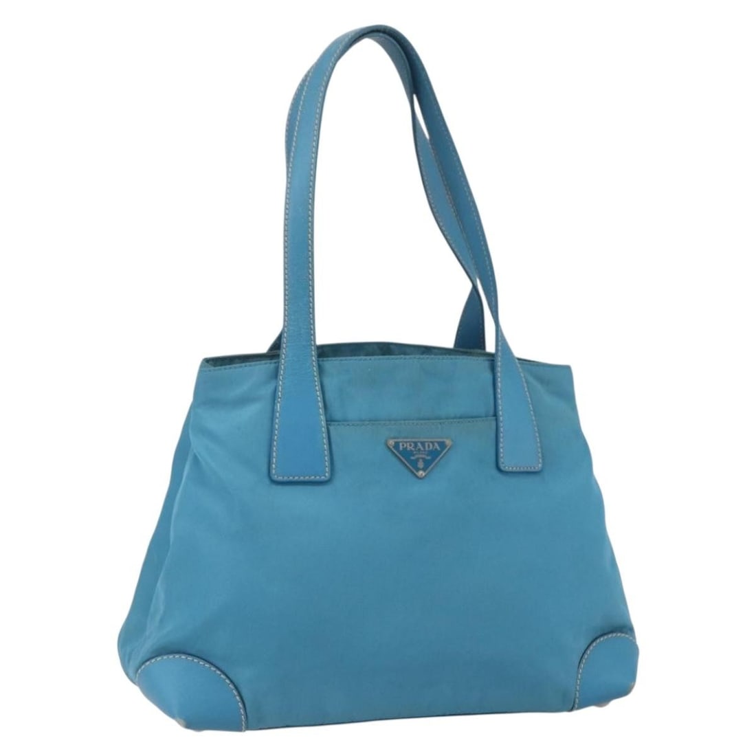 Light Blue Nylon Prada Handbag with Silver Accents Made in Italy: Light Blue Nylon Prada Handbag with Silver Accents Made in Italy This PRADA handbag is crafted from light blue nylon with silver-tone accents. Made in Italy, it features a spacious interior and a prac