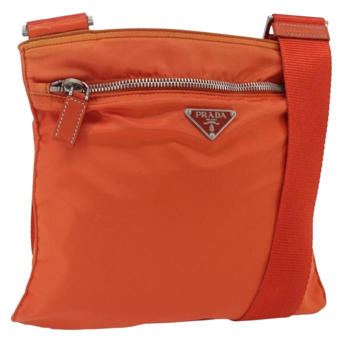 Prada Orange Nylon Shoulder Bag with Silver Leather Trim Italy: Prada Orange Nylon Shoulder Bag with Silver Leather Trim Italy This PRADA shoulder bag is crafted from orange nylon with silver-tone accents. Designed in Italy, it features an adjustable shoulder stra