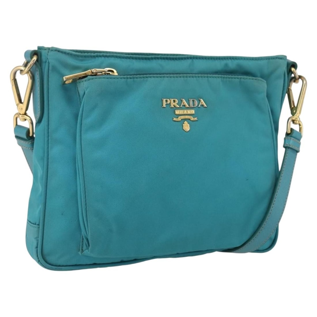 Light Blue Nylon Prada Shoulder Bag with Gold Accents: Light Blue Nylon Prada Shoulder Bag with Gold Accents This PRADA shoulder bag features a light blue nylon exterior with gold accents. Made in Italy, it offers a practical design with a main compartmen