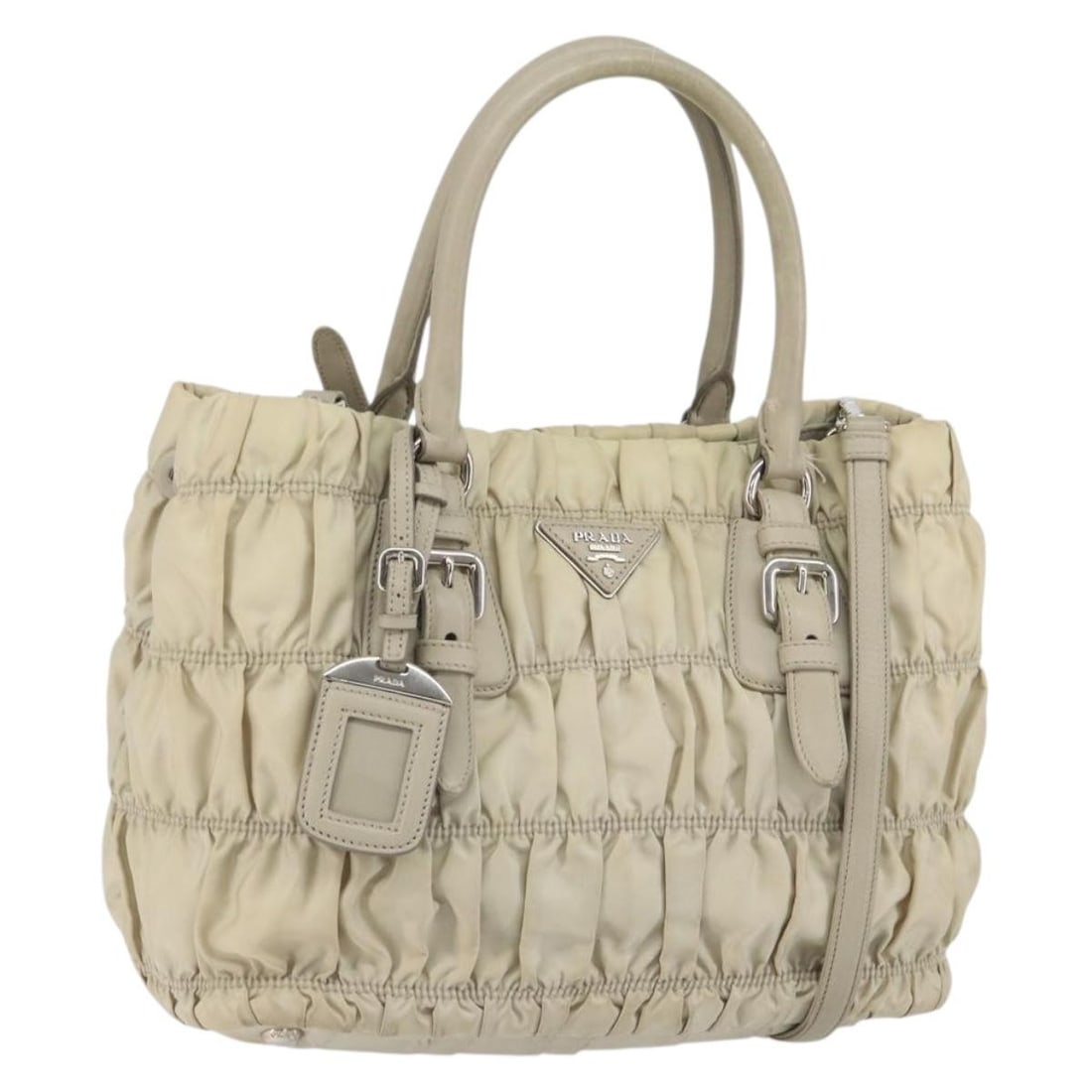 Prada Beige Nylon Convertible Handbag with Shoulder Strap and Name Tag: Prada Beige Nylon Convertible Handbag with Shoulder Strap and Name Tag This PRADA 2-way handbag is crafted from beige nylon with silver-tone accents. Designed for versatility, it features both handles