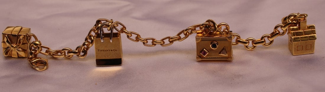 18K Tiffany & Co. Charm Bracelet with Diamond Ruby Sapphire and Box: 18K Tiffany & Co. Charm Bracelet with Diamond Ruby Sapphire and Box Discover the exquisite charm of this Tiffany & Co. 18K gold charm bracelet, a luxurious accessory that combines elegance with playfu