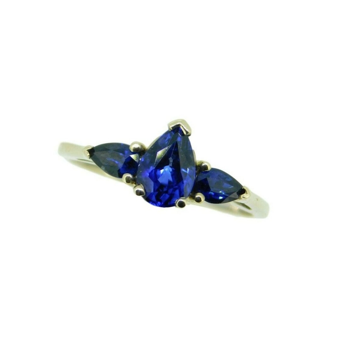 14k White Gold 3 Stone Ring with 1.49 Carat Blue Sapphire: 14k White Gold 3 Stone Ring with 1.49 Carat Blue Sapphire This stunning 14k white gold three-stone ring features a captivating royal blue pear-shaped genuine natural sapphire weighing 1.03 carats.