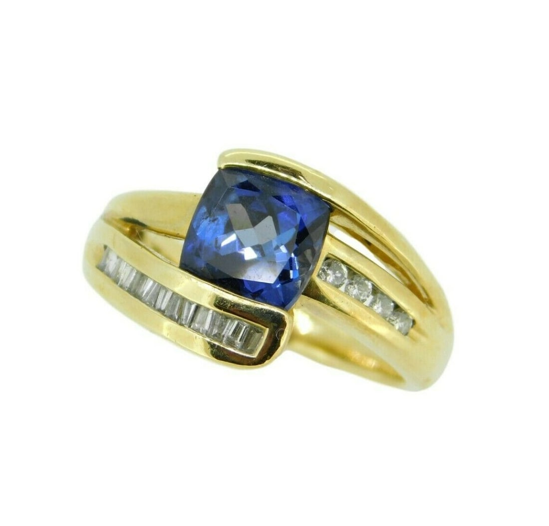 1ct Cushion Cut Tanzanite Ring with 11 Diamonds in 14k Yellow Gold: 1ct Cushion Cut Tanzanite Ring with 11 Diamonds in 14k Yellow Gold This stunning ring showcases a 1ct cushion cut genuine natural tanzanite, beautifully set in 14k yellow gold. The tanzanite, measurin