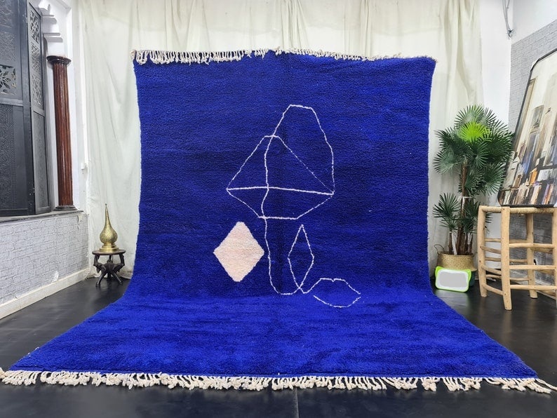 Authentic Handmade Moroccan Blue Berber Wool Rug 9.84 x 6.56 feet: Authentic Handmade Moroccan Blue Berber Wool Rug 9.84 x 6.56 feet Enhance your space with this Authentic Stunning Soft Blue Handmade Moroccan Berber Wool Rug. Featuring a lovely white design in the ce