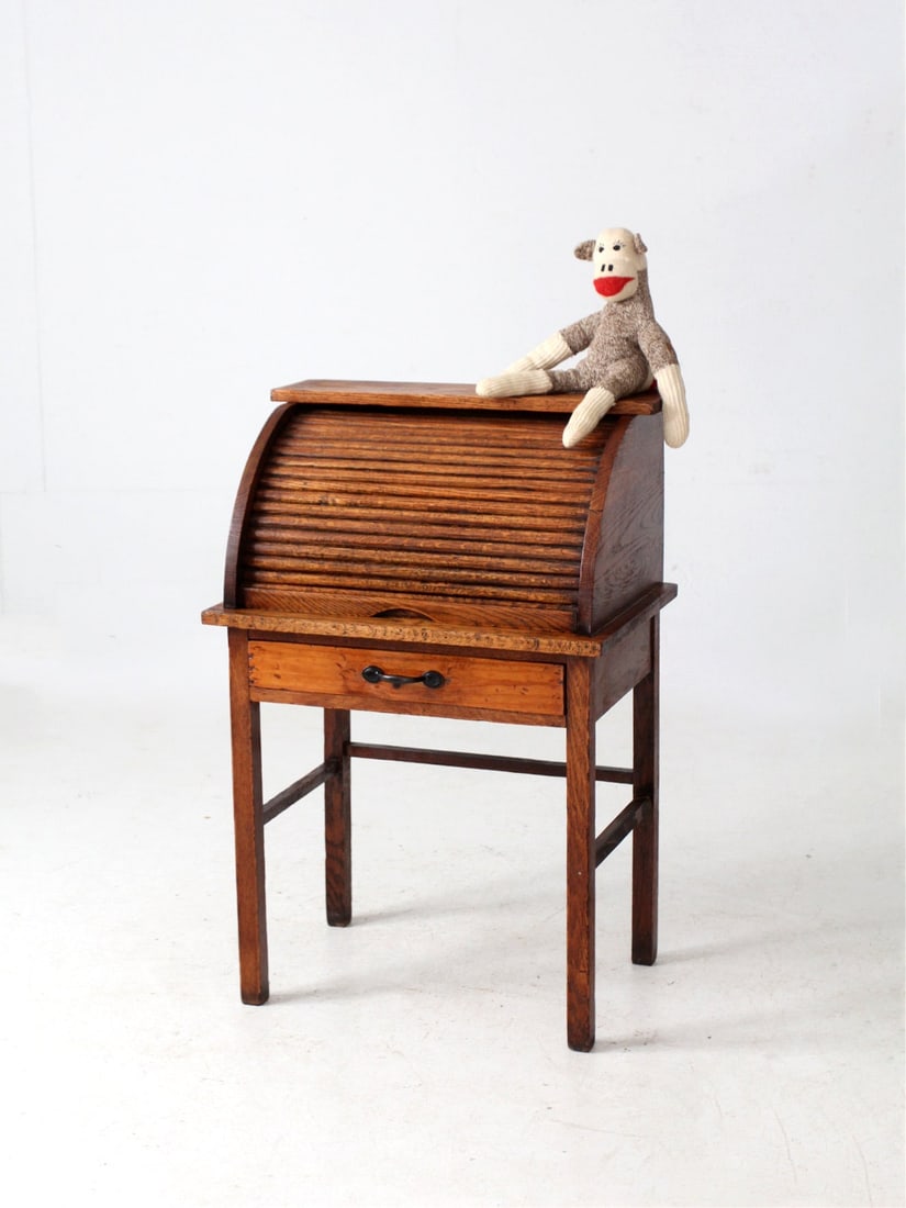 Vintage Child's Oak Roll-Top Secretary Desk with Cubbies: Vintage Child's Oak Roll-Top Secretary Desk with Cubbies This charming early 20th-century child's roll-top secretary desk is expertly crafted from warm oak, showcasing a classic tambour cover and a si