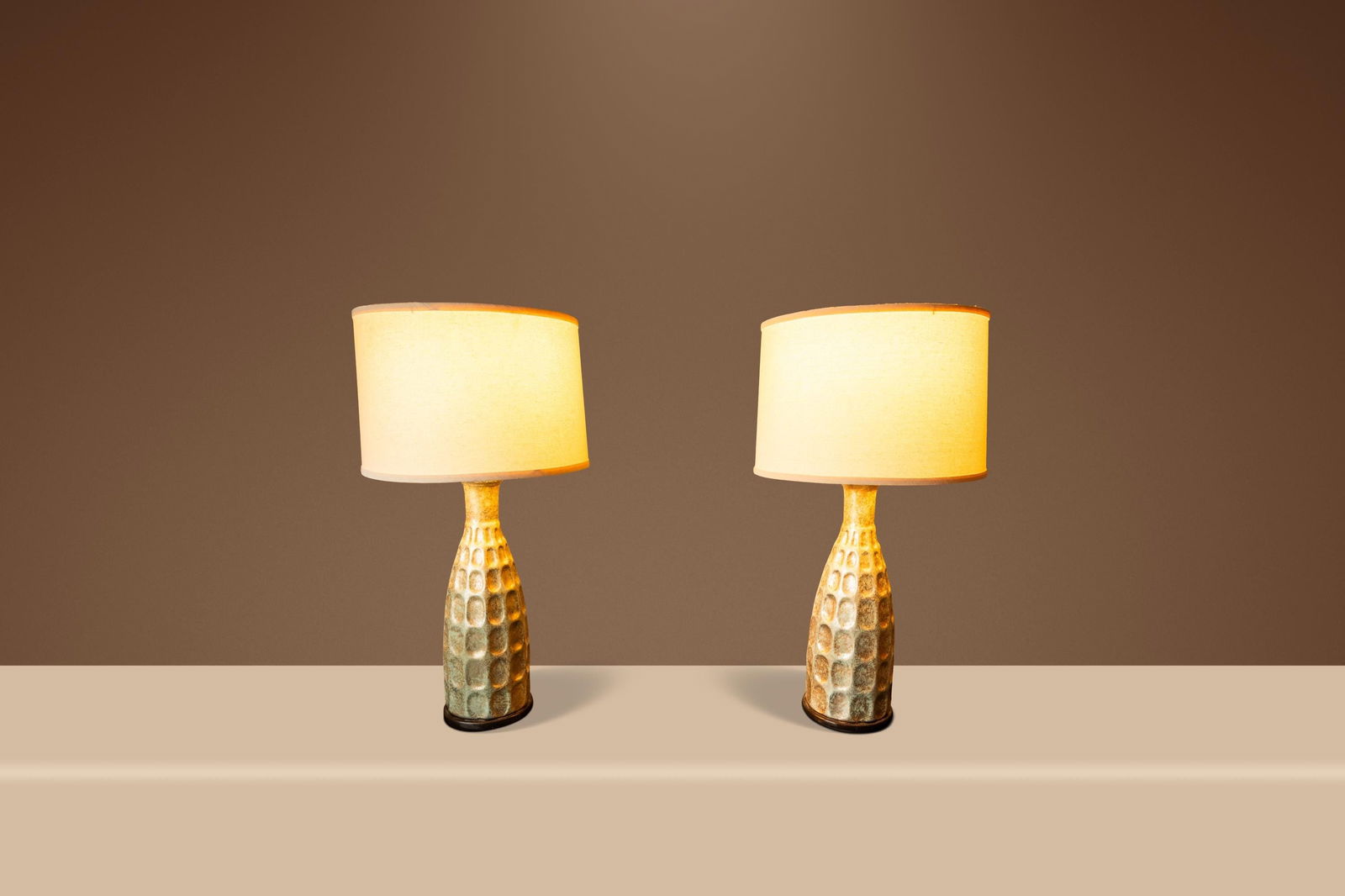 Pair of 1970s Mid-Century Textured Rough Glazed Ceramic Table Lamps: Pair of 1970s Mid-Century Textured Rough Glazed Ceramic Table Lamps This set includes two vintage Mid-Century Modern table lamps from the 1970s, crafted in the United States. Each lamp features a text