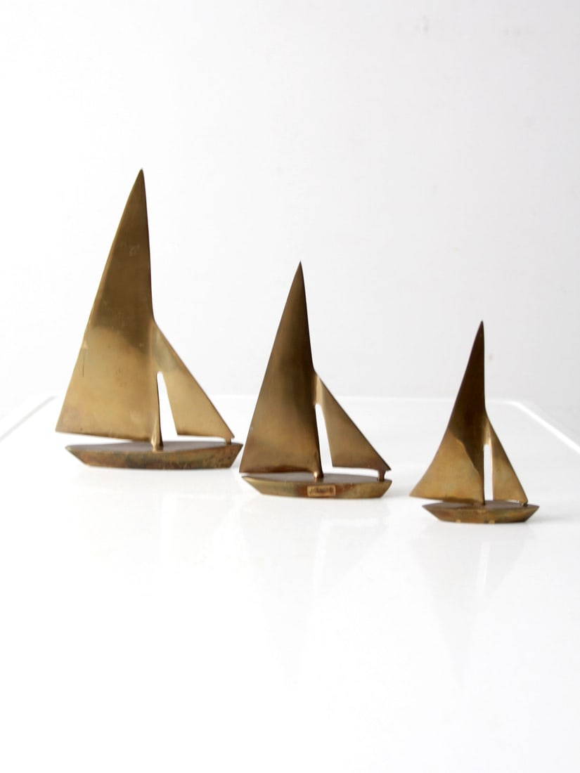 Charming Set of 3 Mid Century Brass Sailboats Nautical Decor: Charming Set of 3 Mid Century Brass Sailboats Nautical Decor This delightful set of three mid-century brass sailboats adds a charming nautical accent to your decor. Each boat varies in size, creating