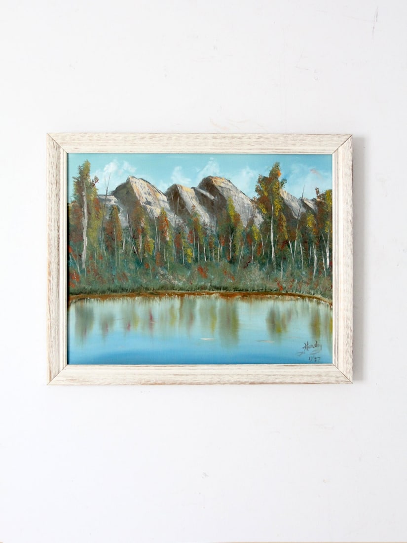 Signed Vintage Mountain Lake Oil Painting in White Frame: Signed Vintage Mountain Lake Oil Painting in White Frame This exquisite vintage canvas painting showcases a tranquil lake surrounded by aspen trees, with gently rendered mountains receding into the ba