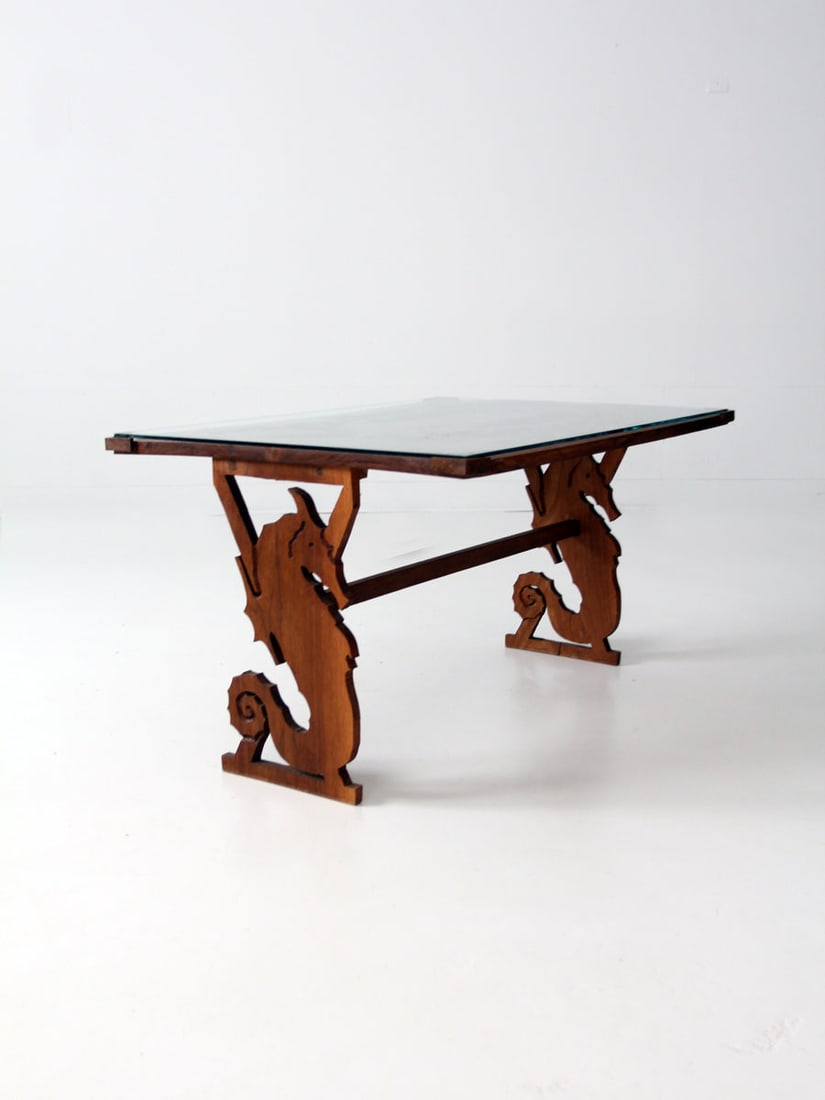 Handmade 1988 Carved Seahorse and Fish Coffee Table with Glass Top: Handmade 1988 Carved Seahorse and Fish Coffee Table with Glass Top This handmade seahorse coffee table, signed and dated 1988, features a trestle base of mirrored, carved seahorses that support a glas