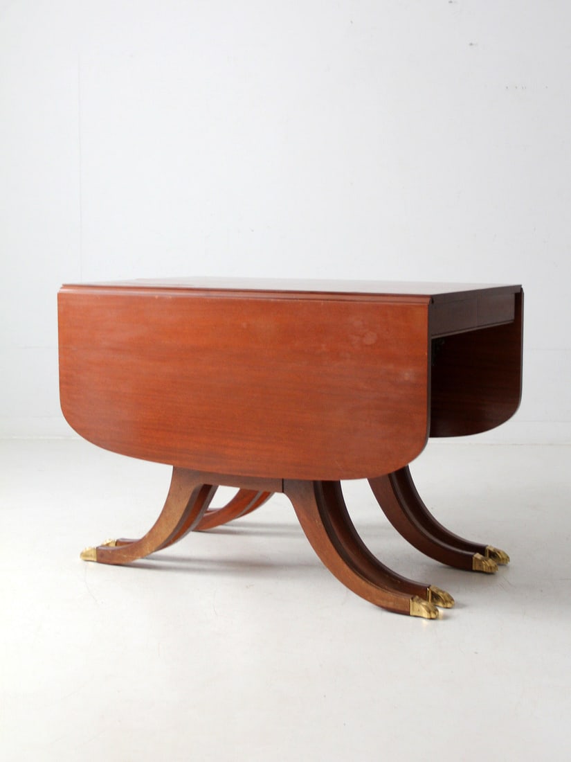 Early 20th Century Duncan Phyfe Drop Leaf Table with Saber Legs: Early 20th Century Duncan Phyfe Drop Leaf Table with Saber Legs This exquisite early 20th-century drop-leaf table is crafted in the classic Duncan Phyfe style, featuring elegant sweeping saber legs an