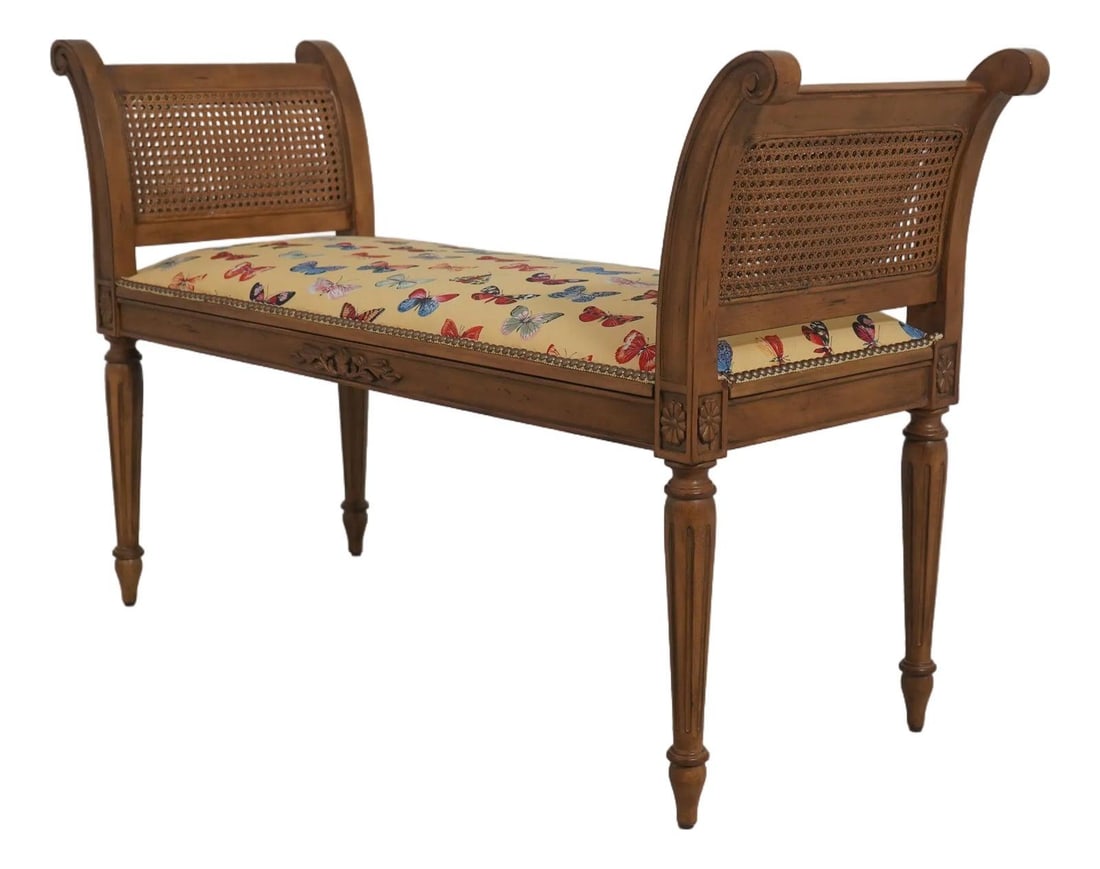 Double Cane Walnut Window Bench in French Louis XVI Style: Double Cane Walnut Window Bench in French Louis XVI Style This French Louis XVI style window bench features double cane sides and a professionally reupholstered butterfly fabric seat. The bench showca