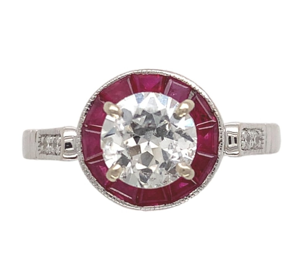 14k White Gold Halo Ring .80ct Diamond Ruby Accents #J7265: 14k White Gold Halo Ring .80ct Diamond Ruby Accents #J7265 This exquisite 14k White Gold ring features a stunning .80ct European cut genuine natural diamond at its center, flanked by a halo of vibrant