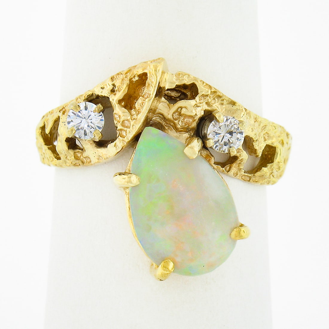 Vintage 14k Yellow Gold Pear Opal Diamond Chevron Ring: Vintage 14k Yellow Gold Pear Opal Diamond Chevron Ring This stunning vintage ring showcases a beautifully crafted 14k yellow gold design featuring an exquisite pear cabochon opal. The opal, measuring
