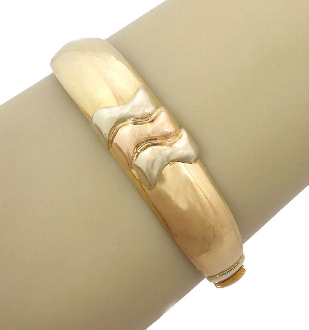 Vintage 18k Two Tone Gold Hinged Dome Bangle by Darnlaion: Vintage 18k Two Tone Gold Hinged Dome Bangle by Darnlaion This vintage hinged dome bangle bracelet is crafted from 18k two tone gold, featuring both yellow and rose gold for a distinctive look. The br