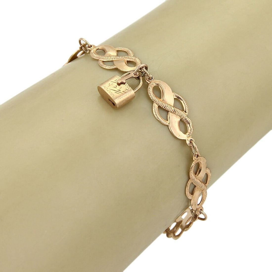 14k Rose Gold Victorian Bracelet with Padlock Charm and Curved Fancy Links: 14k Rose Gold Victorian Bracelet with Padlock Charm and Curved Fancy Links This Victorian bracelet features an intricate curved link design with a padlock charm, crafted from 14k rose gold. The piece