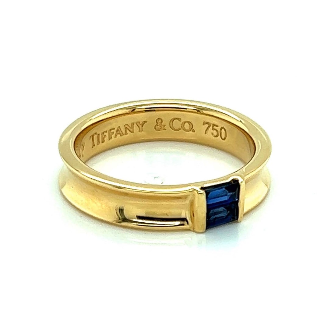 Baguette Sapphire Concave Band in 18k Yellow Gold by Tiffany Size 6: Baguette Sapphire Concave Band in 18k Yellow Gold by Tiffany Size 6 This Tiffany & Co. concave band ring features baguette-cut sapphires set in 18k yellow gold. The ring is signed by Tiffany & Co. and