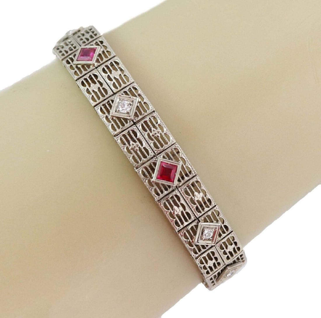Vintage 18k White Gold Art Deco Filigree Bracelet with Diamonds and Synthetic Rubies: Vintage 18k White Gold Art Deco Filigree Bracelet with Diamonds and Synthetic Rubies This vintage Art Deco bracelet is crafted from solid 18k white gold, featuring intricate filigree and milgrain deta