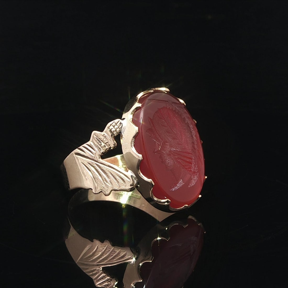 Signet Ring in 18k Yellow Gold with Carved Carnelian Intaglio Trojan Design: Signet Ring in 18k Yellow Gold with Carved Carnelian Intaglio Trojan Design This vintage signet ring features a carved intaglio of a Trojan motif in a deep orange, natural oval-cut carnelian gemstone.