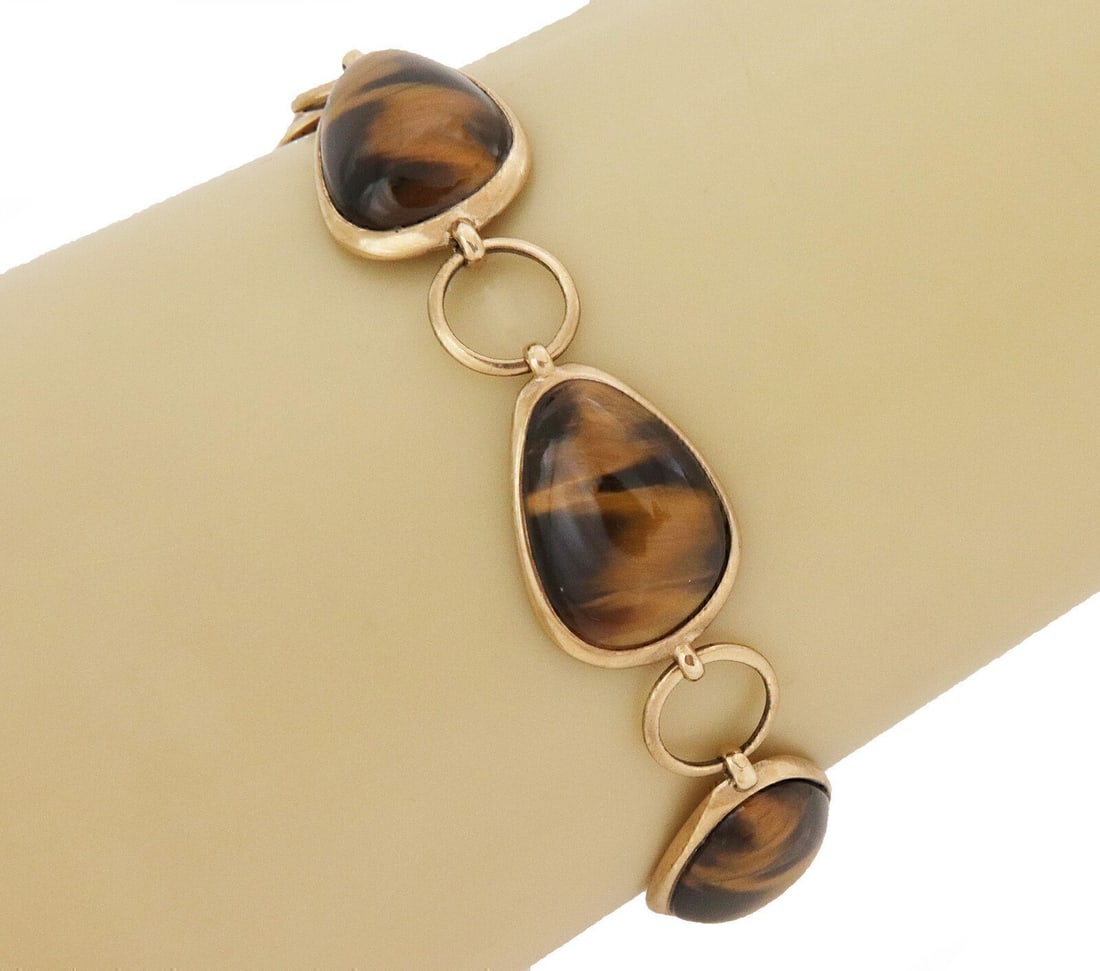 Vintage 9kt Yellow Gold Link Bracelet with Tiger's Eye Gemstone: Vintage 9kt Yellow Gold Link Bracelet with Tiger's Eye Gemstone This vintage link bracelet features intricately designed fancy links crafted from 9kt yellow gold, highlighted by a striking Tiger's Eye