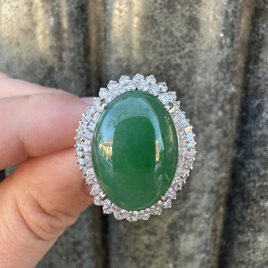 GIA Certified A Jadeite Green Cabochon and Diamond Double Halo Ring in White Gold: GIA Certified A Jadeite Green Cabochon and Diamond Double Halo Ring in White Gold This striking ring features a large, natural Type A jadeite jade cabochon weighing 14.81ct, certified by GIA, set at