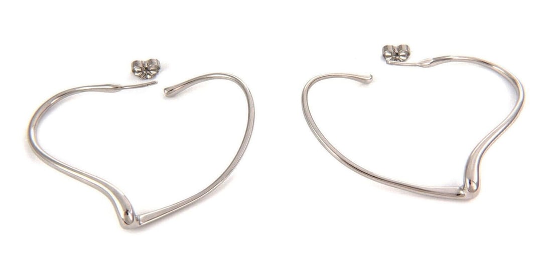 Pair of Sterling Silver Open Heart Hoops by Tiffany & Co.: Pair of Sterling Silver Open Heart Hoops by Tiffany & Co. This pair of vintage Tiffany & Co. large open heart hoop earrings is crafted from sterling silver. Featuring a classic hoop design with an ope