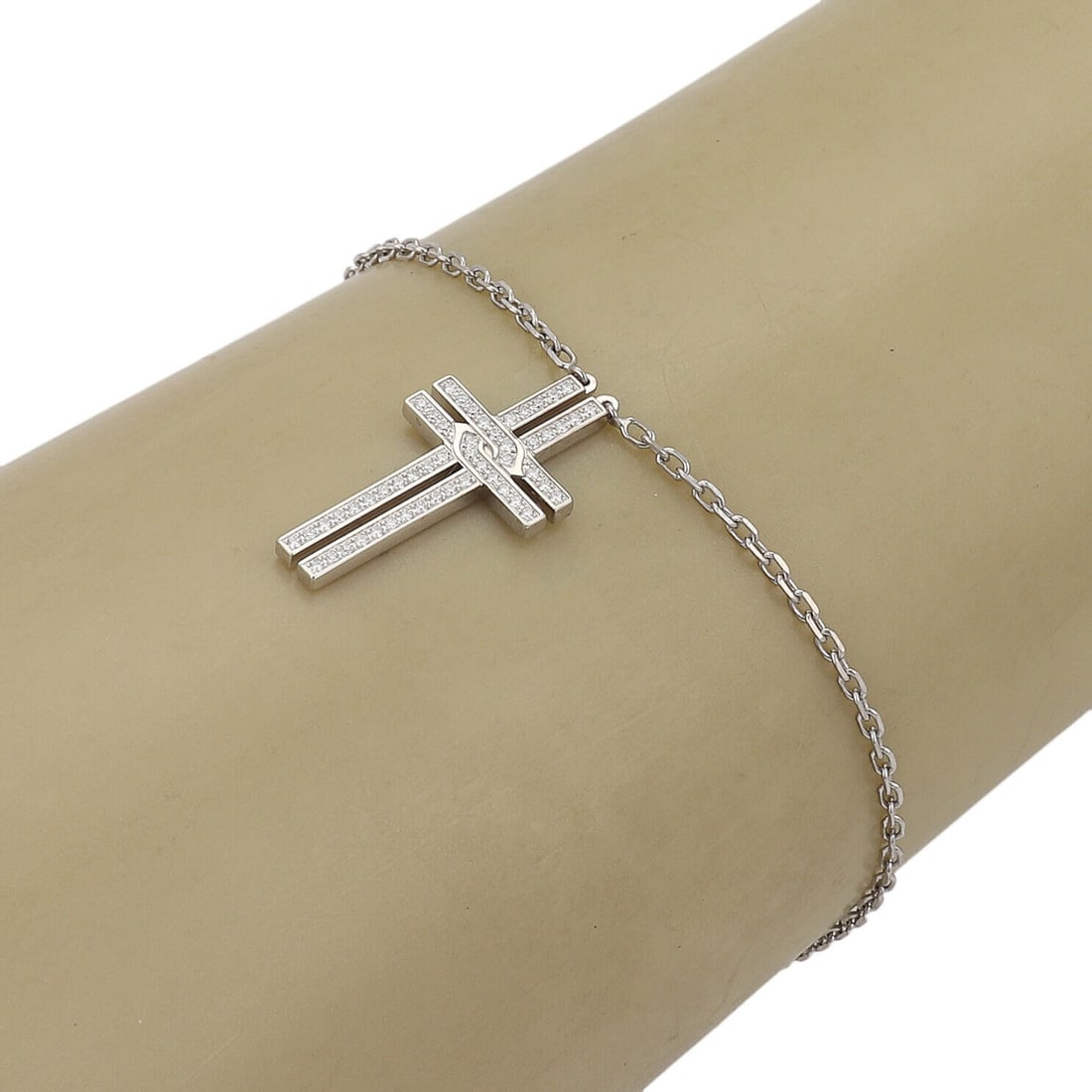 Diamond Cross Charm Bracelet in 18k White Gold by Cartier with Papers: Diamond Cross Charm Bracelet in 18k White Gold by Cartier with Papers This Cartier charm bracelet is crafted from 18k white gold and features a dangle cross charm adorned with approximately 0.15 carat